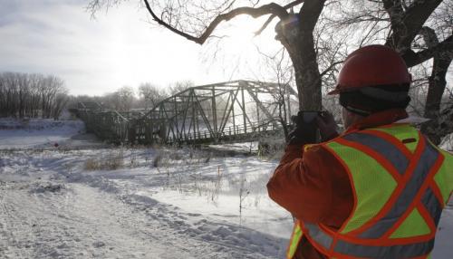 A member of the demolision crew takes some photos after the St. Jean Baptiste bridge was demolished around 9 a.m. Saturday morning in front of a gathering of townspeople and local residents. 130216 - Saturday, February 16, 2013 -  (MIKE DEAL / WINNIPEG FREE PRESS)