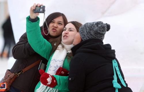 Elisa Chen, 22, Susan Capelle, 27, and Kenia Salmeron, 22, taking a group photo in front of a snow sculpture at the Festival du Voyageur, Saturday, February 16, 2013. (TREVOR HAGAN/WINNIPEG FREE PRESS)