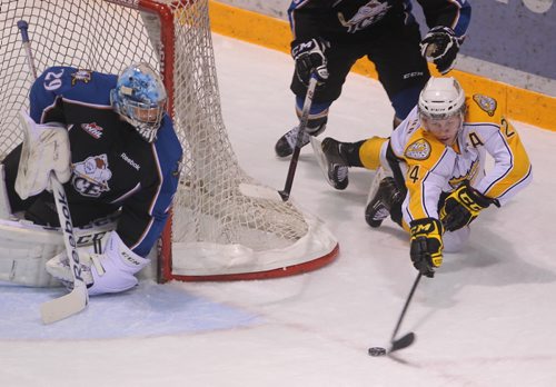 Brandon Sun Wheat Kings Jens Meilleur plays the puck from his knees drawing a penalty on the Kootenay Ice in the first period of Saturday night's WHL game at Westman Place. (Bruce Bumstead/Brandon Sun)
