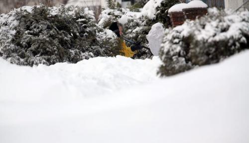 A woman digs through the snow on her walkway on Inkster, Monday, February 18, 2013. (TREVOR HAGAN/WINNIPEG FREE PRESS)