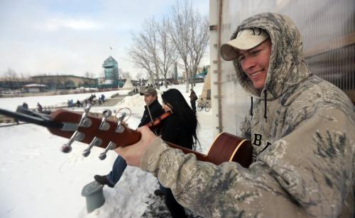 Josh Gareau, right, plays guitar with Darryl St. Goddard and Melissa St. Goddard near a warming hut by the Assiniboie River at The Forks as part of the Music on Ice event, Sunday, February 17, 2013. (TREVOR HAGAN/WINNIPEG FREE PRESS)