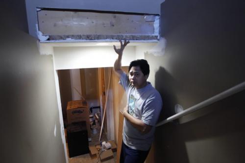 Arnel Mercado lives in a Pritchard Avenue home (695 Pritchard) that was built with falsified engineering seals, which the city is now investigating. Mercado said the city did not discover the problem until he applied for a permit to renovate his basement in November. Arnel is in the stairway to the basement where the Inspector found the headroom  for stairs too low to meet code. He is holding a support beam. Jen Skerritt  story    (WAYNE GLOWACKI/WINNIPEG FREE PRESS) Feb. 19 2013