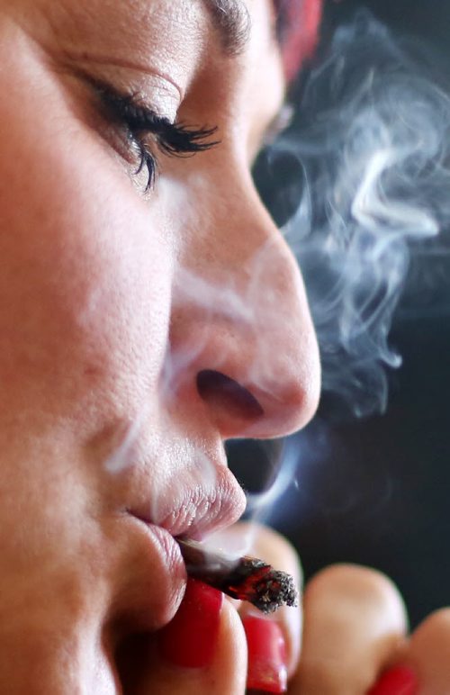 Brandon Sun 19022013 Jade Ridge, CEO and founder of the Canadian Medical Marijuana Clinic (CMMC) based in Brandon, Manitoba, smokes marijuana in the living room of her home. (Tim Smith/Brandon Sun) ***HOLD FOR BILL REDEKOP STORY****