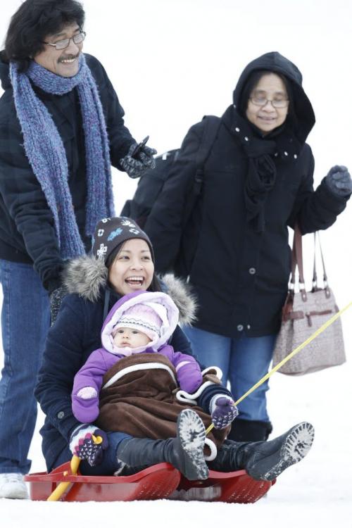 Koun Thepanya and his wife, Souloth, their daughter, Noy and her daughter, Ariella, 6 months, all from Toronto, enjoying a mild afternoon at the Festival du Voyageur, Saturday, February 23, 2013. (TREVOR HAGAN/WINNIPEG FREE PRESS)