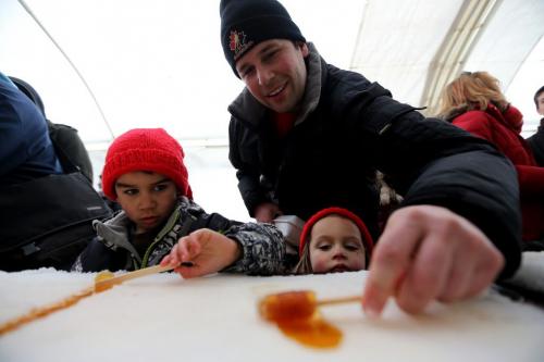 Roger Vermette helps his children, Maxime, 6, and Jasmine, 3, to get taffy at the Festival du Voyageur, Sunday, February 24, 2013. (TREVOR HAGAN/WINNIPEG FREE PRESS)