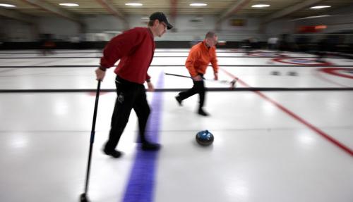 It's not "offside" as sweepers Boissevain's Mike Cuvalier (in red) and Killarney's Kelvin McMullen sweep a rock across the blue line and towards the hog line at the Carberry Curling Club's annual community bonspiel. Featuring over a hundred teams, the spiel utilized the community hockey ice for a week and is a success story in the rural curling world. Feb 21, 2013 - (Phil Hossack / Winnipeg Free Press)