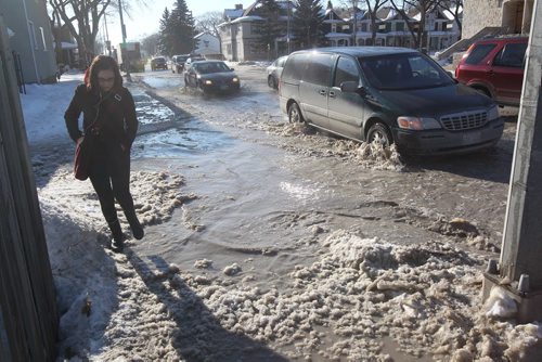 A pedestrian navigates through high water caused by a watermain break at Corydon and Stafford Ave Tuesday morning  Standup photo- February 26, 2013   (JOE BRYKSA / WINNIPEG FREE PRESS)