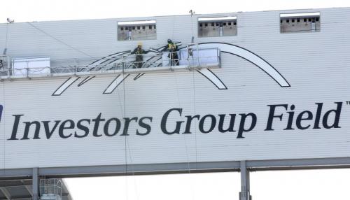 Workers put up the logo on the rear of the giant monitor at Investors Group Field on University of Manitoba campus Thursday afternoon See Bartley Kives story- February 28, 2013   (JOE BRYKSA / WINNIPEG FREE PRESS)