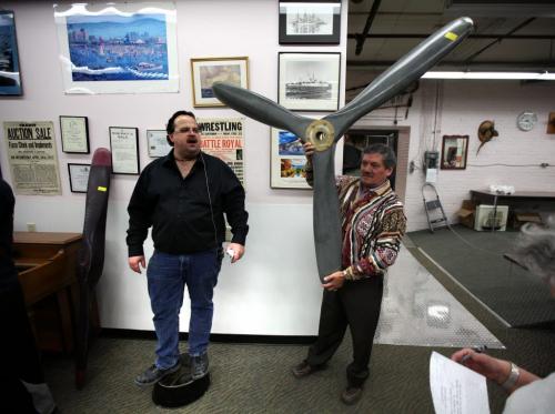FOR BUSINESS -  Jason Kaye looks for bis while Don Pottinger holds up an airplane propeller for sale at a weekly Thursday night auction at Kaye's...See Randy Turner's story. Feb 28, 2013 - (Phil Hossack / Winnipeg Free Press)