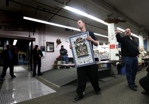 FOR BUSINESS - Auctioneer Jason Kaye (right) signals the sakle of an autographed Goldeye's poster while assistant  "jr", Darrell Warren delivers to goods at a weekly Thursday night auction at Kaye's...See Randy Turner's story. Feb 28, 2013 - (Phil Hossack / Winnipeg Free Press)