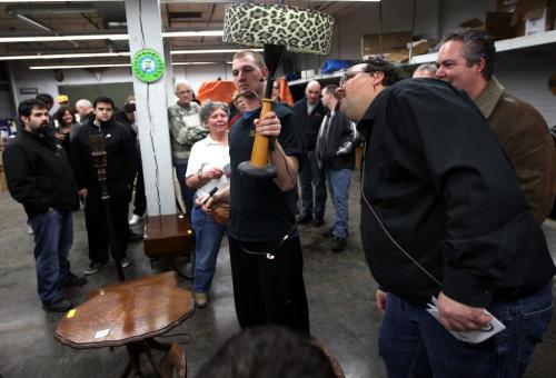 FOR BUSINESS - Auctioneer Jason Kaye checks the bulbs in a lamp before auctioning it off, assistant "Jr" Darrell Warren displays the goods at a weekly Thursday night auction at Kaye's...See Randy Turner's story. Feb 28, 2013 - (Phil Hossack / Winnipeg Free Press)