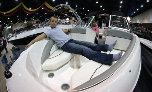 Jackson Godfrey, 10, stretches out with his sister, Lexa, 7, at the wheel, during the 2013 Mid Canada Boat Show at the Winnipeg Convention Centre, Friday, March 1, 2013. (TREVOR HAGAN/WINNIPEG FREE PRESS)