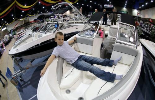 Jackson Godfrey, 10, stretches out with his sister, Lexa, 7, at the wheel, during the 2013 Mid Canada Boat Show at the Winnipeg Convention Centre, Friday, March 1, 2013. (TREVOR HAGAN/WINNIPEG FREE PRESS)