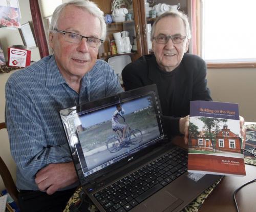 left Alvin Suderman  and right Rudy Friesen author of   Building on the Past , Mennonite Architecture  , Landscape and Settlements in Russia / Ukraine,-   Bill Redekop story about  their group helping the people of Ukraine , this boy on computer screen named Sasha has no arms was provided with a modified bike  that lets hi steer with his shoulders , they also supply computers and school supplies  KEN GIGLIOTTI / Mar. 5 2013 / WINNIPEG FREE PRESS