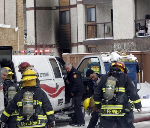 Fire Fighters at the scene of a fire in a suite (in background) in the Linden Woods Village 173 Victor Lewis Dr. Tuesday afternoon. Geoff Kirbyson story.WAYNE GLOWACKI/ WINNIPEG FREE PRESS) WINNIPEG FREE PRESS  March 5 2013