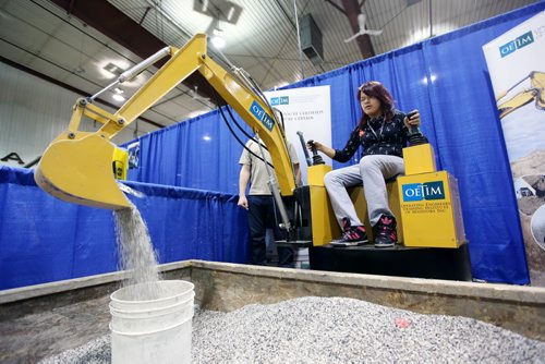 Brandon Sun 05032013 Maples Collegiate student Leigha Cloud operates a scaled down digger at the Operating Engineers Training Institute of Manitoba booth during the 28th Annual Brandon Career Symposium at the Keystone Centre on Tuesday. (Tim Smith/Brandon Sun)