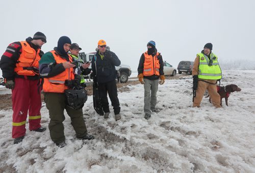 Brandon Sun GSAR searchers set their initial way-point into their GPS units before heading out in search of the mock crash site on Sunday. (Bruce Bumstead/Brandon Sun)