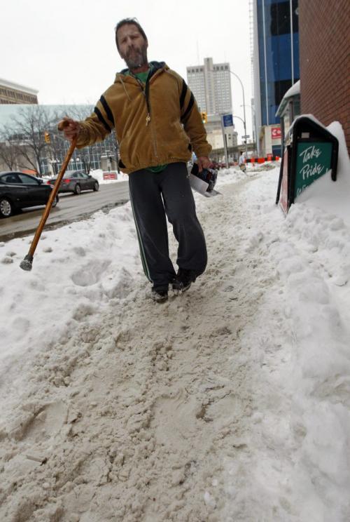 Mark Norman needs a cane to walk has tough time  on Smith St. - Walking the Slippery Walk  in downtown Wpg , unploughed  sidewalks , slushy  snow conditions making walking difficult after the large snow fall of the past week Äì gordon sinclair story - KEN GIGLIOTTI / Mar. 6 2013 / WINNIPEG FREE PRESS