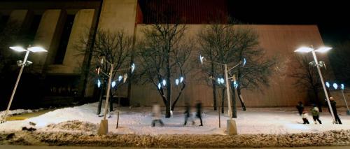 Concert goers walk along Market ave beside the Centennial Concert Hall amongst a new lighting display meant to mimick the Aurora Borealis, like a legend claims the Aurora come closer when one whistles, the lighting display changes color and brightens as pedestrians whistle at them. See release... - March 6, 2013 - (Phil Hossack / Winnipeg Free Press)