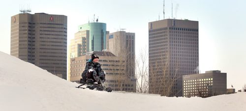 Justin Courchaine (8) takes advantage of a beautiful afternoon and an empty sledding hill at the Forks Friday. With the downtown sky line behind him Justin enjoyed the mild temps and sunshine while weekend temps are????? March 8, 2013 - (Phil Hossack / Winnipeg Free Press)
