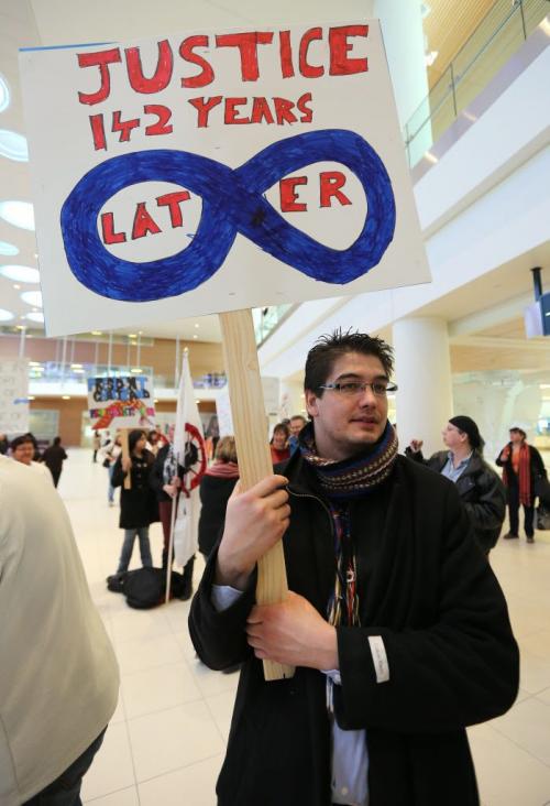 Johnny Einarson holds a sign while awaiting the arrival of Manitoba M¾©tis Federation president David Chartrand at Winnipeg Richardson Airport on Sat., March 9, 2013. On March 8, 2013, the Supreme Court ruled the federal government was "ineffectual and inequitable" in how it handed out land to M¾©tis children in Manitoba more than 130 years ago. Photo by Jason Halstead/Winnipeg Free Press