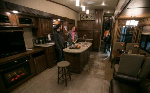 Blake and Nikki Spence admire a 11.8 metre long fifth-wheel travel trailer at the Winnipeg RV Show on Saturday. The two-level trailer has a fireplace and king size bed. To tow the 12,076 lbs trailer needs a special hitch in the bed of a pick-up truck. (Melissa Tait / Winnipeg Free Press)