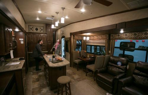 Blake and Nikki Spence admire a 11.8 metre long fifth-wheel travel trailer at the Winnipeg RV Show on Saturday. The two-level trailer has a fireplace and king size bed. To tow the 12,076 lbs trailer needs a special hitch in the bed of a pick-up truck. (Melissa Tait / Winnipeg Free Press)