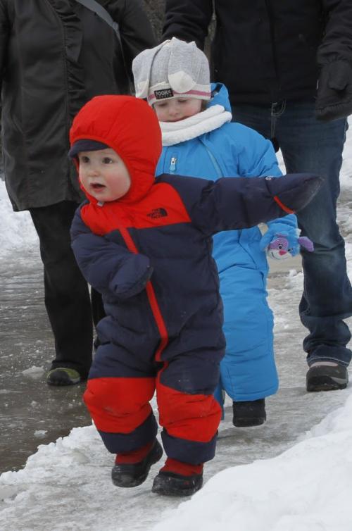 Eighteen-month old Tyrus (foreground) navigates the icy Riverwalk at The Forks with his friend Olivia, age 2, with their mothers Monday morning. (JESSICA BURTNICK/WINNIPEG FREE PRESS) March 11, 2013