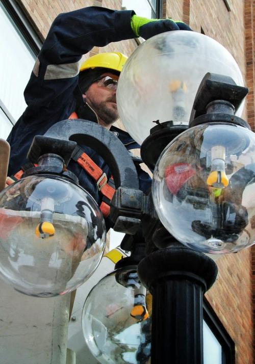 Greg van den Ham installs LED bulbs into the old style street lights located in Winnipeg's Exchange District downtown.  130311 March 11, 2013 Mike Deal / Winnipeg Free Press