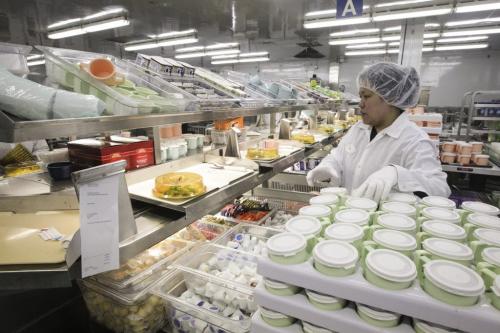 Diet Aid, Pia Tan, surrounded by various foods prepares patients trays as they travel along a conveyor belt in the main tray assembly centre during a tour of the Regional Distribution Facility at the WRHA Nutrition and Food Services Centre at 345 De Baets Street in St. Boniface.  Note: The name of the patient has been blurred on the meal ticket in the left side of the image to protect their privacy.  130312 - Tuesday, March 12, 2013 -  (MIKE DEAL / WINNIPEG FREE PRESS)