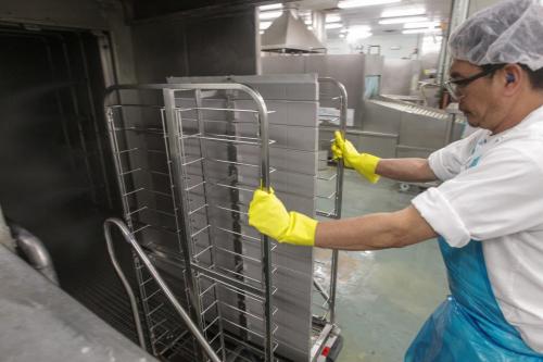 Joselito Mendoza wheels a tray rack into a large washing machine for sanitization during a tour of the Regional Distribution Facility at the WRHA Nutrition and Food Services Centre at 345 De Baets Street in St. Boniface.  130312 - Tuesday, March 12, 2013 -  (MIKE DEAL / WINNIPEG FREE PRESS)