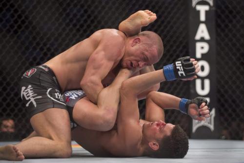 Georges St-Pierre, left, from Canada pins Nick Diaz from the United States to the canvas during their UFC 158 title fight in Montreal, Saturday, March 16, 2013. THE CANADIAN PRESS/Graham Hughes.