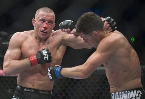 Georges St-Pierre, left, from Canada lands a blow to Nick Diaz from the United States during their UFC 158 welterweight title fight in Montreal, Saturday, March 16, 2013. THE CANADIAN PRESS/Graham Hughes.