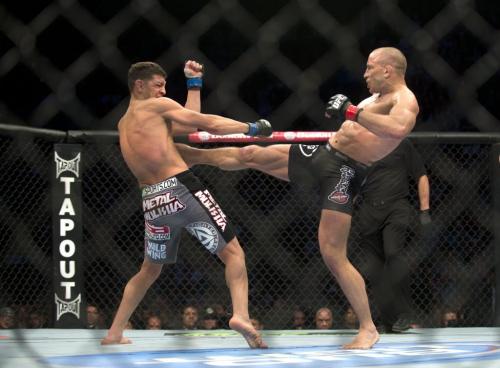 Georges St-Pierre, right, from Canada lands a kick to the body of Nick Diaz from the United States during their UFC 158 welterweight title fight in Montreal, Saturday, March 16, 2013. THE CANADIAN PRESS/Graham Hughes