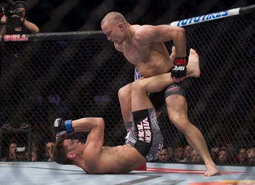 Georges St-Pierre, right, from Canada pins Nick Diaz from the United States to the canvas during their UFC 158 welterweight title fight in Montreal, Saturday, March 16, 2013. THE CANADIAN PRESS/Graham Hughes.