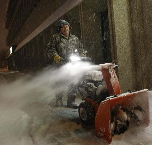 Omer Lacoursiere clears the snow around the Carpathia Credit Union on Main Street early Monday morning, this was his first job and expects a busy day ahead with more snow in the forecast.  For weather story  story(WAYNE GLOWACKI/WINNIPEG FREE PRESS) Winnipeg Free Press March 18 2013