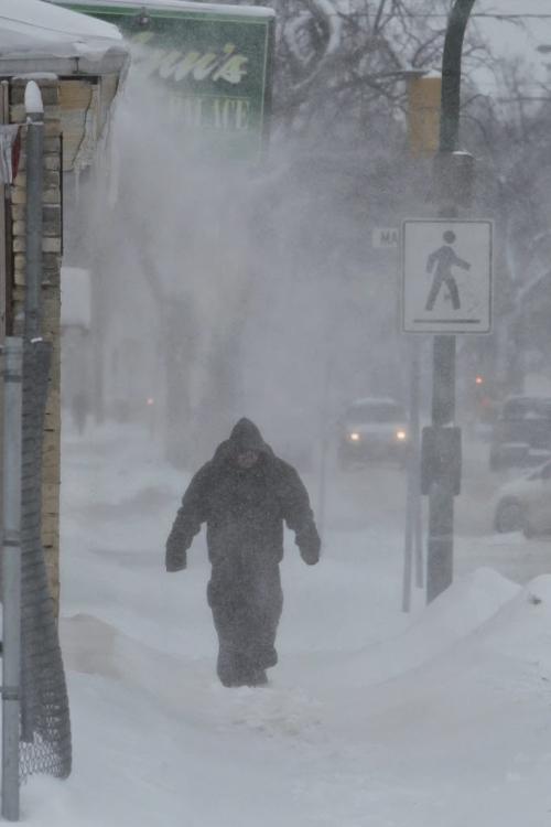 A pedestrian walks along Salter Street in the blowing snow Monday morning.  130318 March 18, 2013 Mike Deal / Winnipeg Free Press