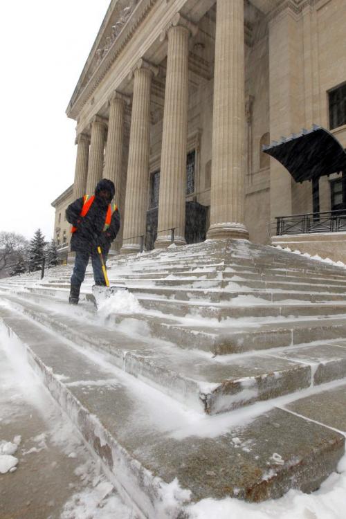 A Manitoba government groundskeeper shovels off the front steps of the Legislature Building. Weather standup. March 18, 2013  BORIS MINKEVICH / WINNIPEG FREE PRESS