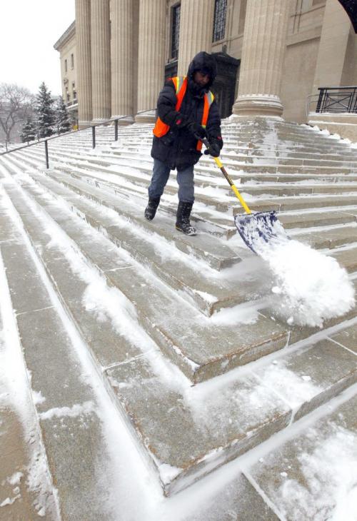 A Manitoba government groundskeeper shovels off the front steps of the Legislature Building. Weather standup. March 18, 2013  BORIS MINKEVICH / WINNIPEG FREE PRESS