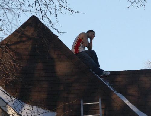 On the Roof- A man who tried to evade police from capture ended up stranded on a second storey roof in the block of 400 Furby St in Winnipeg Thursday morningPolice had to call in the Fire Department to bring a aerial ladder to rescue the man. He ended up surrendering himself to police for a safe ride down - March 21, 2013   (JOE BRYKSA / WINNIPEG FREE PRESS)
