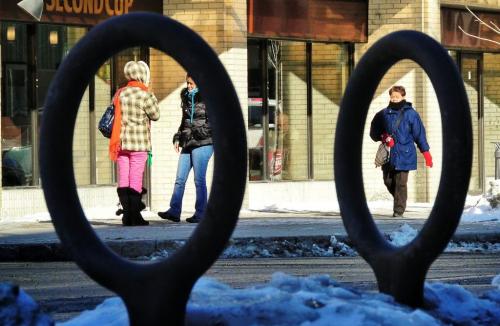 Pedestrians are framed by bicycle stands as they walk along Edmonton Street in Downtown Winnipeg Thursday morning.   130321 March 21, 2013 Mike Deal / Winnipeg Free Press