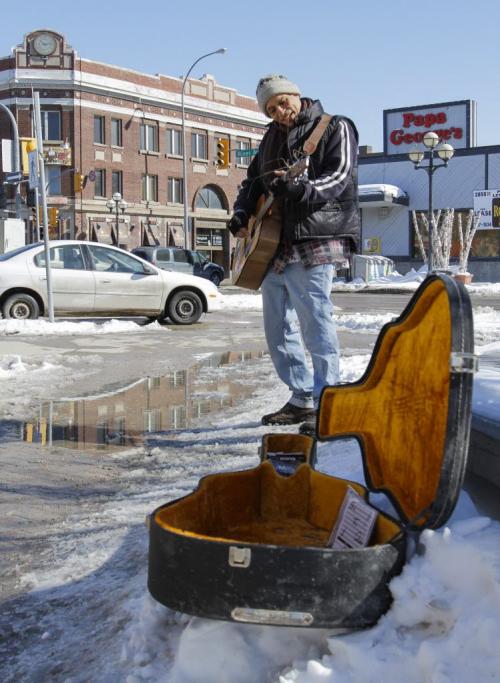 It appears that Eric "The Great" Pyle couldn't have chosen a nicer day to busk on the corner of River Ave. and Osborne St. on Friday, March 22, 2013, but he says he's a regular on the popular street corner and uses his guitar to spread love to others. (JESSICA BURTNICK/WINNIPEG FREE PRESS)