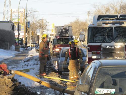 STEPH CROSIER / WINNIPEG FREE PRESS   Firefighters convene after responding to a fire at 325 Provencher Boulevard Friday evening.