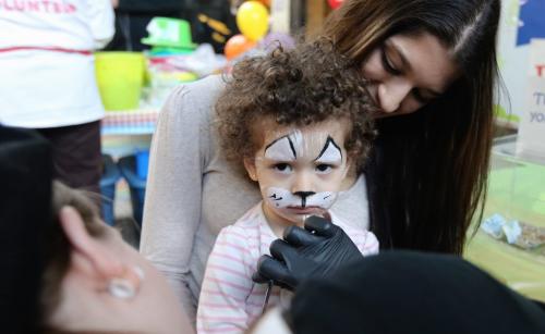 Layah Marino, 2, with her mom Stacy, having her face painted by Kira Selch, at The Festival of Fools, at The Forks, Saturday, March 23, 2013. ( TREVOR HAGAN/WINNIPEG FREE PRESS)