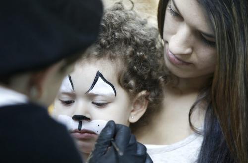 Layah Marino, 2, with her mom Stacy, having her face painted by Kira Selch, at The Festival of Fools, at The Forks, Saturday, March 23, 2013. ( TREVOR HAGAN/WINNIPEG FREE PRESS)