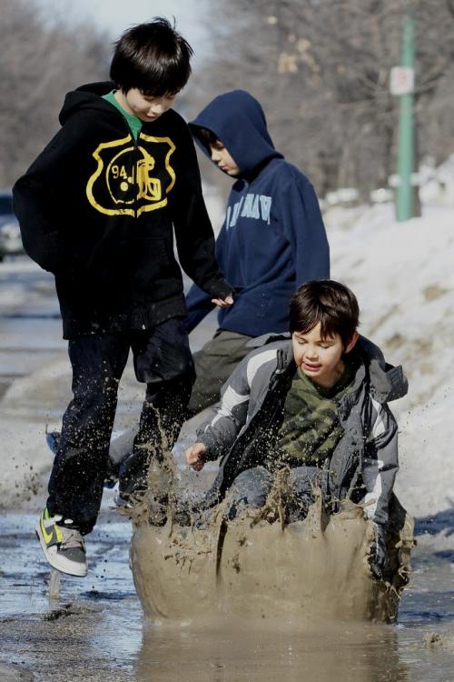 March 25, 2013 - 130325  -  Brothers (LtoR) Dakota (10), Carson (8), and Brandon (6) Harper have some fun in a puddle in the Robertson area of Winnipeg Monday, March 25, 2013. John Woods / Winnipeg Free Press