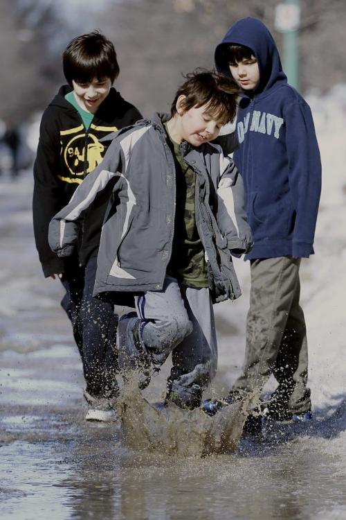 March 25, 2013 - 130325 - Brothers (LtoR) Dakota (10), Brandon (6), and Carson (8) Harper have some fun in a puddle in the Robertson area of Winnipeg Monday, March 25, 2013. John Woods / Winnipeg Free Press