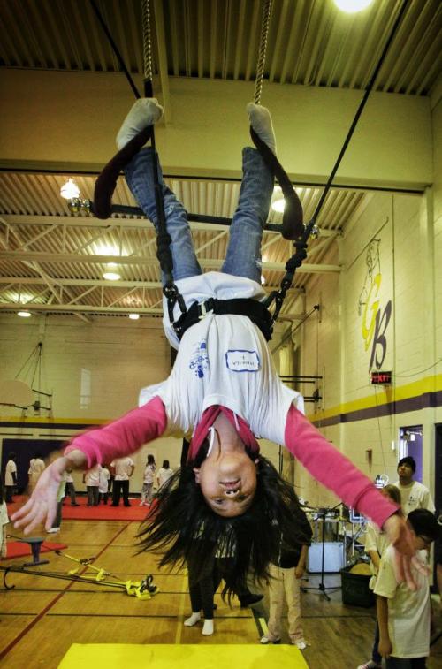 Macayla Baldovi, 10, swings on a trapeze during the Circus and Magic Partnership (CAMP) being held at Gordon Bell High School. More than 250 at-risk kids are taking part in the program during spring break, a program that gives them opportunities to learn to juggle, walk on a tightrope and stilts, swing on a trapeze, aerial dance, magic tricks and more. 130327 March 27, 2013 Mike Deal / Winnipeg Free Press