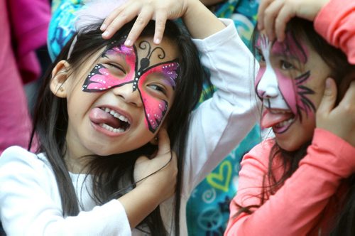 Five year old Maddy Rivero makes funny faces with her friend Kiara Pastora -  6 years while watching children's entertainer Mr. Mark at the 13th Annual Festival of Fools at the Forks Saturday afternoon. Standup Photo Photography Ruth Bonneville  Ruth Bonneville /  Winnipeg Free Press)