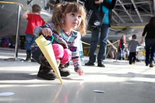 The Western Canadian Aviation Museum was host to hundreds of little egg hunters of all ages Saturday morning for their  annual Easter Egg Hunt.  Three year old Alana Waruk picks up paper eggs that she can redeem for real chocolate eggs after her hunt. Standup Photo Photography Ruth Bonneville  Ruth Bonneville /  Winnipeg Free Press)